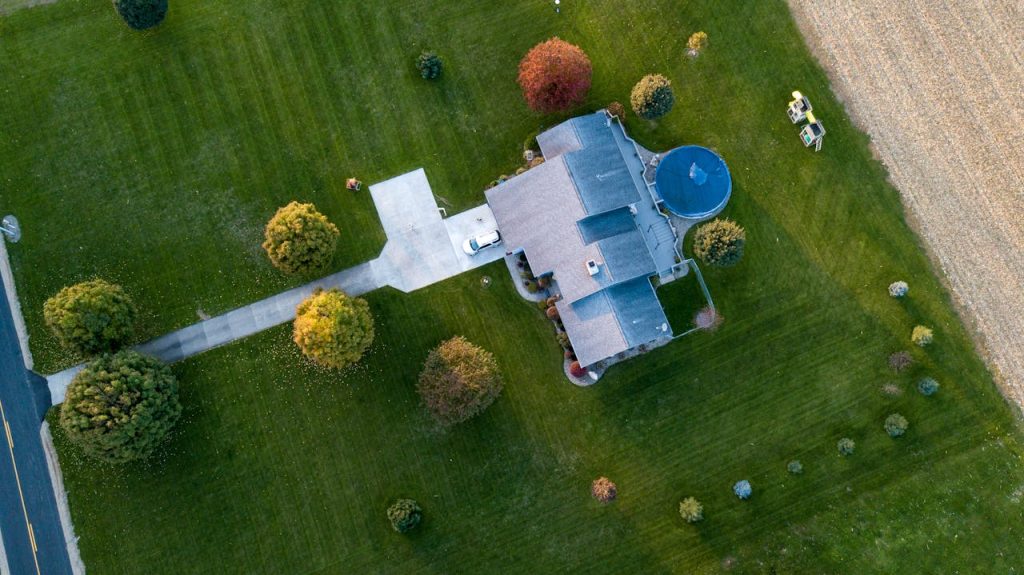 aerial-photography-of-gray-house-1590336 Aerial view of a suburban house with a pool, surrounded by green lawns and autumn trees, in Tipton, Indiana.