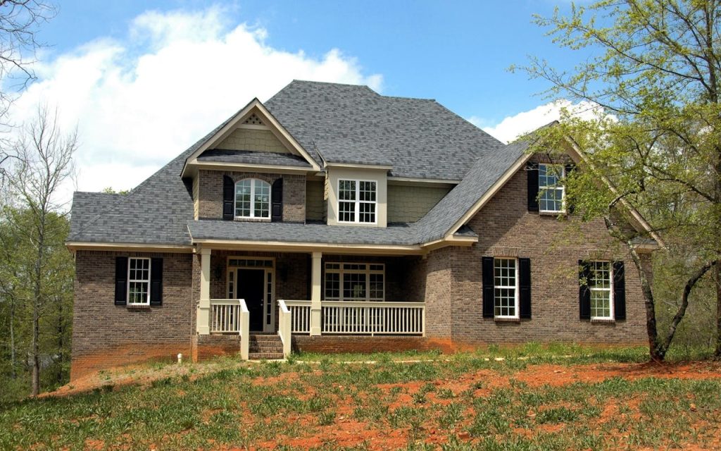 brown-wall-paint-house-near-at-garden-209315 Classic two-story brick house with gable roof and front lawn in suburban setting.