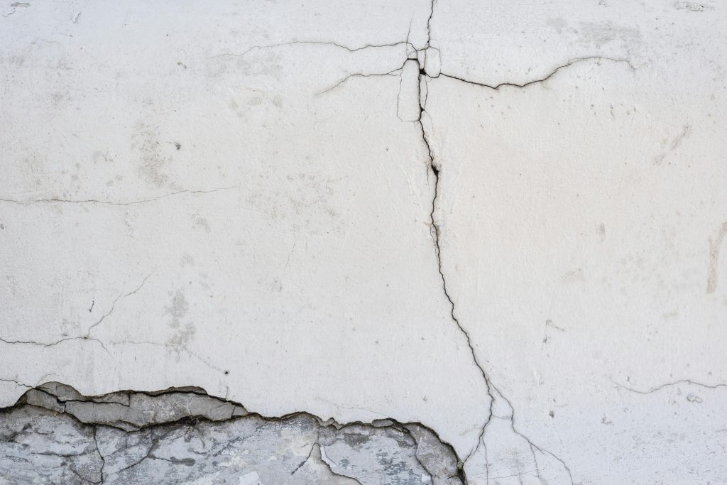 Close-up of a cracked concrete wall showing surface texture details.